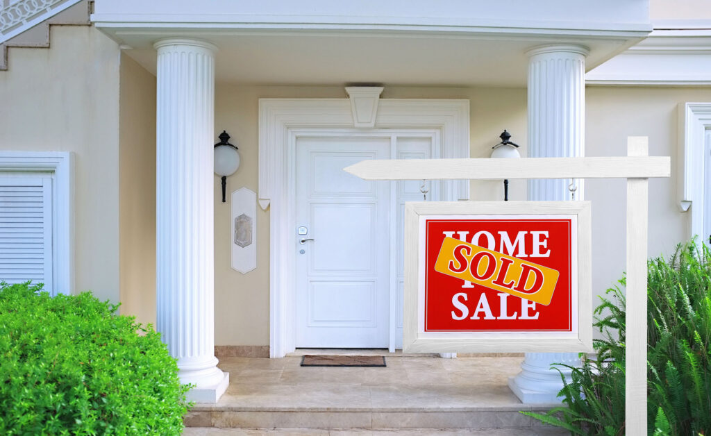 home for sale with sold sticker on sign